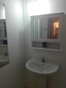 里瓦德塞利亚Camping Playa Sauces的白色的浴室设有水槽和镜子