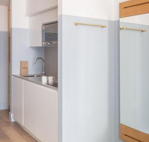 伦敦莱蒙洛克公寓式酒店的厨房配有白色橱柜和水槽