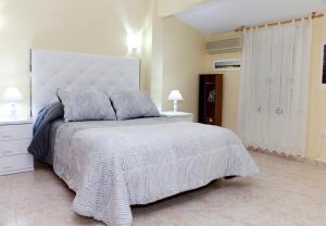 哈兰迪雅·德·拉·维尔Apartamentos La Relojera 2的一间卧室配有一张带白色床罩的大床