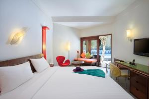 勒吉安ibis Styles Bali Legian的一间卧室配有一张床、一张书桌和一台电视