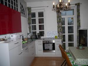 霍佩加尔滕Ferienwohnung im Neubauernweg 3的厨房配有白色橱柜、桌子和吊灯。