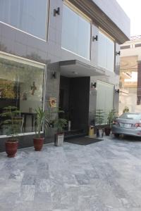 伊斯兰堡Hotel One Super, Islamabad的停在有盆栽植物的建筑外的汽车