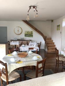 CuremonteLe Moulin de Lassalle的一间带桌椅和楼梯的用餐室