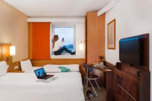 布拉格布拉格马拉斯特拉纳宜必思酒店的酒店客房设有两张床,窗户上配有一台笔记本电脑