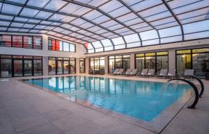 圣普列斯特里昂东基里亚德名誉酒店及SPA - 圣牧师乌里克斯珀的一个带玻璃天花板的大型游泳池