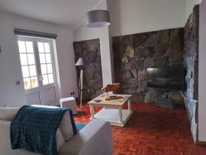 大里贝拉Margarida House - Stone Apartment的客厅设有石墙和电视。