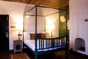 NamchiThe Temi Bungalow South Sikkim的一间卧室配有一张带两盏灯的天蓬床。