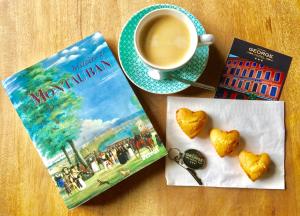 蒙托邦商务酒店的书和一杯咖啡,紧挨着心形饼干