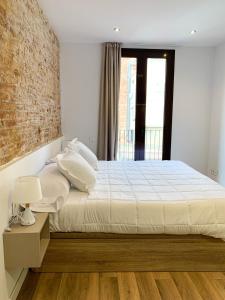 巴塞罗那LucasLand Apartments Barcelona的一间卧室设有一张床和砖墙
