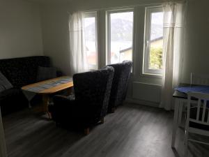 ToftaFjordgård B的一间带桌椅和窗户的用餐室