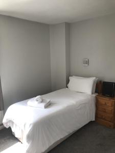 CuckfieldThe Wheatsheaf Inn的卧室配有白色的床和电视。