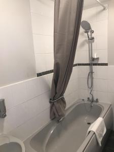 CuckfieldThe Wheatsheaf Inn的浴室设有带浴帘的浴缸