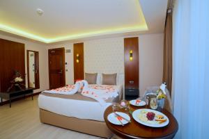 伊斯坦布尔My Dream Istanbul Hotel的酒店客房,配有一张床和一张带食物盘的桌子