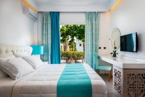 马斯蒂查里Smy Kos Beach & Splash的一间卧室配有一张床、一张书桌和一个窗户。
