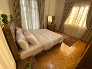 开罗Maspero Nile View Serviced Apartments by Brassbell的一间卧室配有带白色床单和枕头的床。