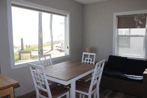 代托纳海滩Shoreline Suites & Cabana Cottages – Beachfront的一间带桌椅和窗户的用餐室