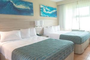 阿瓜迪亚Punta Borinquen Resort的酒店客房设有两张床和窗户。