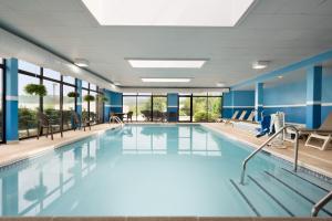 北不伦瑞克Holiday Inn Express & Suites - North Brunswick, an IHG Hotel的一个带蓝色墙壁和窗户的大型游泳池