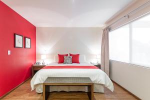 墨西哥城Suites Copérnico Polanco Anzures的一间卧室设有红色墙和一张床