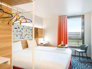 基扬古尔凡尔赛宫基扬古尔宜必思尚品酒店的一间酒店客房,配有一张白色的床和一张书桌