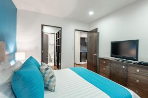 墨西哥城Suites Copérnico Polanco Anzures的一间卧室配有一张大床和一台平面电视