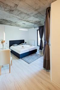 马达伯乐斯拉夫Exclusive penzion Viva Residence的一间卧室设有一张大床和木制天花板