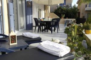 帕福斯Maya's Apartment - Complimentary Paphos Airport Transport的庭院配有椅子、桌子和毛巾