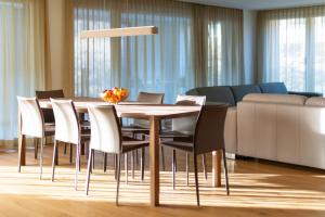 因特拉肯Swiss Hotel Apartments - Interlaken的一间带木桌和椅子的用餐室