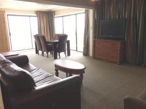 默特尔比奇Polynesian Oceanfront Hotel的客厅配有沙发和桌椅