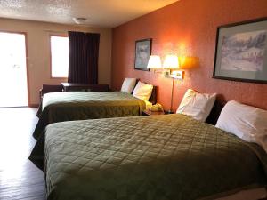 西斯科Lone Star Inn的橙色墙壁的酒店客房内的两张床