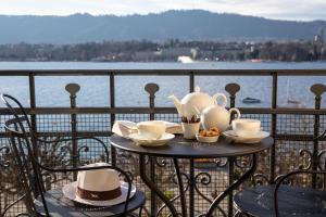 苏黎世La Réserve Eden au Lac Zurich的阳台上的桌子上装有杯子和茶壶