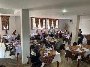 萨帕托卡Hotel Abadias De Zapatoca的一群坐在餐厅桌子上的人