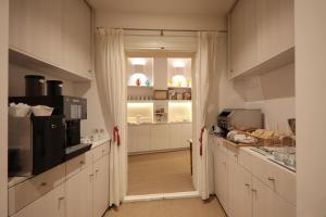 马略卡岛帕尔马帕尔马AH艺术酒店的厨房配有白色橱柜,门通往厨房