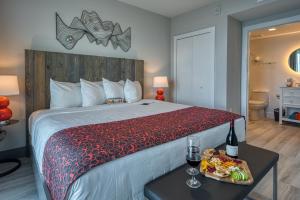 圣徒皮特海滩FUSION Resort Two Bedroom Suites的一间卧室配有一张床铺,桌子上放着一个食物托盘