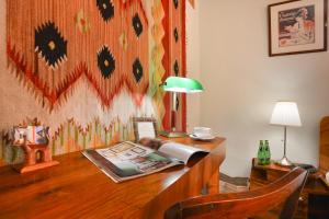 华沙梅斯兹堪可克罗扎姆库酒店的一张桌子,上面有台灯和一本书