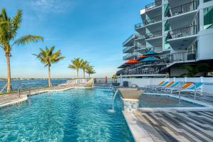 圣徒皮特海滩FUSION Resort Two Bedroom Suites的一座棕榈树游泳池和一座建筑