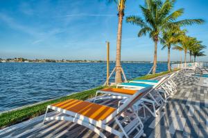 圣徒皮特海滩FUSION Resort Two Bedroom Suites的码头上一排躺椅和棕榈树