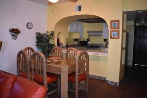 罗萨里托La Paloma Beach&Tennis Resort的厨房以及带木桌和椅子的用餐室。