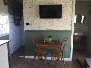 EvandalePeg Cottage的一张桌子、椅子和墙上的电视