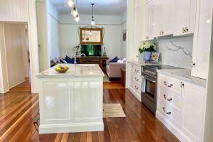 土乌巴Ashbrooke Cottage的厨房配有白色橱柜和台面
