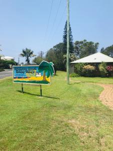 麦夸里港灯塔海滩度假村酒店的路边草上的标志
