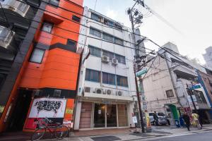 大阪Q旅馆的一条城市街道上的橙色和白色建筑