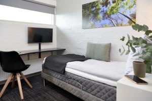 奥胡斯HORISONT Hotel & Konference的一间卧室配有一张床和一张书桌及电视