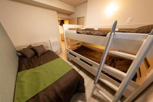 札幌Experience Sapporo的小型客房配有2张双层床和1张床