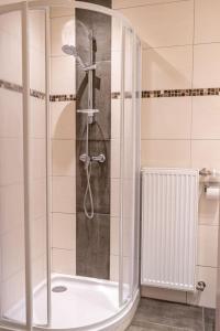 伦韦格沃德霍斯旅馆的浴室里设有玻璃门淋浴
