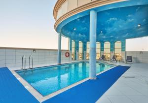 沙迦TIME Express Hotel Al Khan的大楼内的大型游泳池