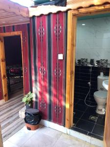 亚喀巴Al-Amer Hostel 1的一间带卫生间和红色墙壁的浴室
