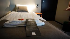 诺尔雪平中央第一酒店的酒店客房,配有一张带标志的床