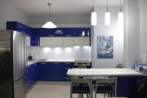 斯巴达Laconian Collection "Lykourgou 10"的厨房配有蓝色橱柜和白色的桌椅