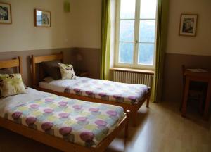 Saint-Julien-Molin-MoletteLa Rivoire的一间卧室设有两张床和窗户。